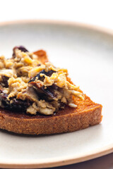 roasted bread served with scrambled eggs and mushrooms