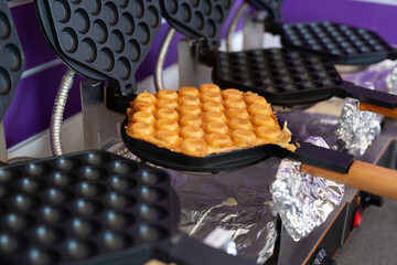 The machine made a bubble waffle in a street cafe. Hong Kong bubble waffle.