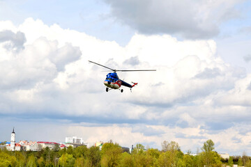 a small helicopter takes off from the field in the city
