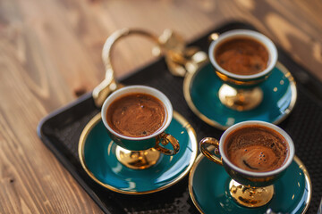 Naklejka premium freshly brewed hot turkish coffee on the table. treating customers with coffee in the office for the sale of apartments in Turkey. black strong coffee in istanbul