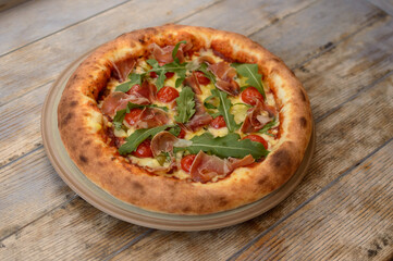 Very tasty pizza on a wooden background.