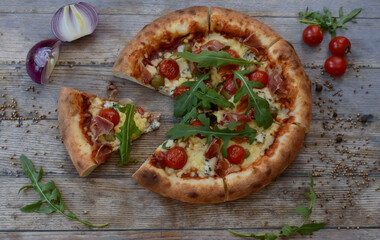 Pizza with cheese and tomato on wooden background with onion.