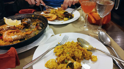 A couple eating Paella and drinking Sangria in a Catalan restaurant. 