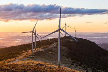 A group of wind mills on a mountain ridge in Austria during sunrise in Austria