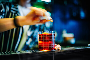 woman hand bartender making negroni cocktail in bar
