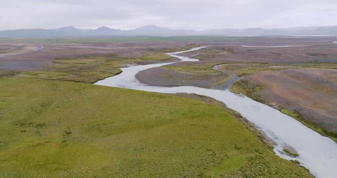 Aerial view, flying sidewards, of winding river Sanda in the desolate highlands of Iceland.