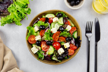 Fresh greek salad with cherry tomato, cucumber, lettuce, black olive, feta cheese and olives oil on...