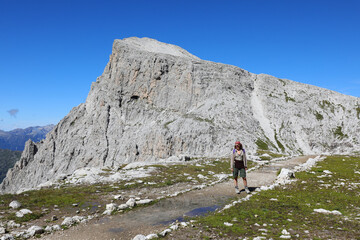 young woman with backpack on her shoulders during the walk on the path