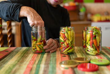 Woman preparing peppers for winter.