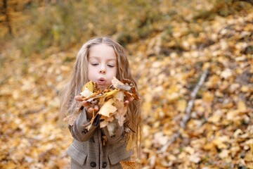 Portrait of a fashion little girl having fun in autumn forest