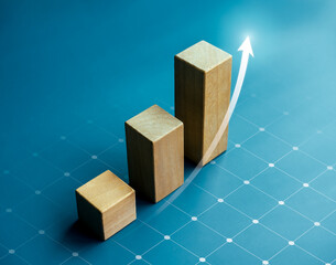 Shining rise up arrow on wooden cube blocks, bar graph chart steps table on blue background,...