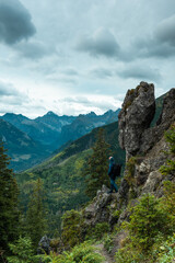 Fototapeta na wymiar Solo hiker standing on edge of rocks in mountains