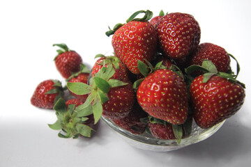 Fresh strawberries in a transparent glass bowl