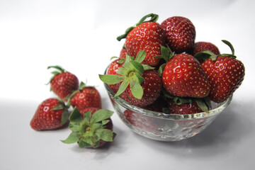 Fresh strawberries in a transparent glass bowl