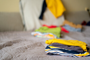 What to wear. Messy colorful clothing on a sofa.