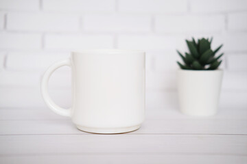 Fototapeta na wymiar White mug mockup for presentation sublimation designs, cup with copy space on front in lifestyle setting