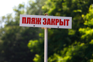 sign with the inscription in Russian the beach is closed