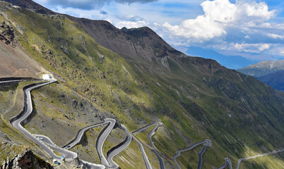 mountain panorama view with forest on the slopes of the mountains. Dramatic, high and beautiful Alps. Beautiful sky over the mountains. The rays of the sun and the road. Travel and challenge. Landscap