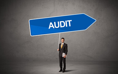 Obraz premium Young business person in casual holding road sign