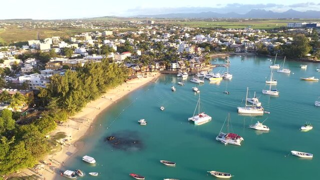 Aerial view of Grand Baie with anchoring boats in the turquoise lagoon and view of the city, Mauritius, Africa.