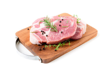 Pieces of pork meat with rosemary and thyme leaves on wood plate isolated on white