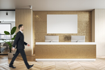 Businessman side view walking by modern reception area in golden color shades office with parquet...