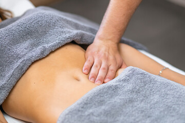 hands of a man massaging a woman's abdomen. Cosmetic procedures in the spa salon, body care,...