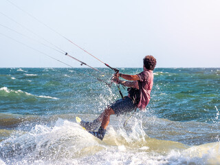 Man practicing kitesurf at sunset. Selective focus.