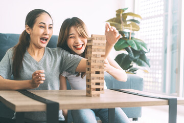 Young adult southeast asian couple relax lifestyle playing jenga board game at home