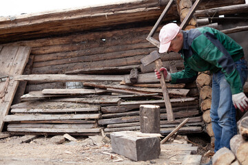 A young man is chopping wood with an axe