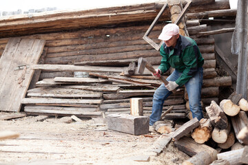 A young man is chopping wood with an axe
