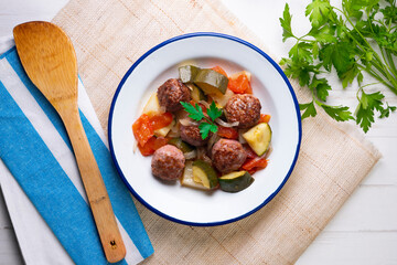 Beef meatballs with tomato sauce and assorted vegetables. Typical Spanish tapas recipe.