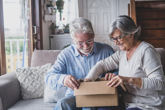 Happy Mature Aged Older Family Couple Unpacking Carton Box, Satisfied With Internet Store Purchase Or Unexpected Gift, Feeling Excited Of Fast Delivery Shipping Service, Positive Shopping Experience..