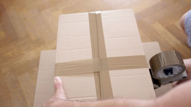 moving house - close up of a hand holding a cardboard box - Video
