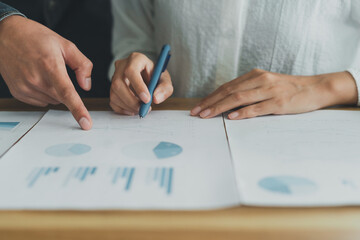 Professional businesswoman and man consulting, working on documents at corporate office. Hands pointing chart paperwork. Team discussion report project finance, planing marketing, statistic analysis