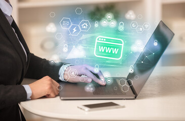 Hands working on laptop with digital icons