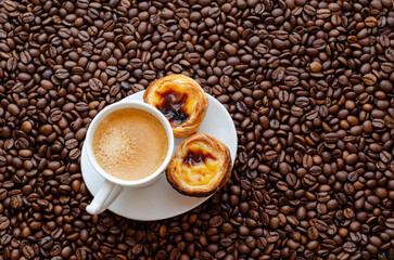 Cup of coffee and coffee beans on table, top view