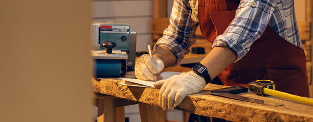 Carpenter man working use pencil sketching design woodwork furniture in carpentry workshop....