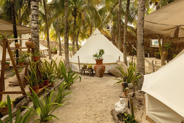 Beautiful Mexican beach tent hotel or hostel. Tents in the jungle decorated with plants and flowers, Tulum, Mexico