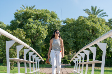 asian girl listening to music with headphones in park