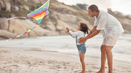 Father teaching child to fly a kite on beach wind with support, love and care. Helping, learning...
