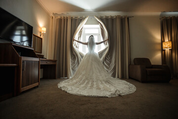 bride in a chic dress tears off the curtains