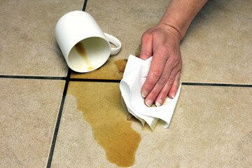 cleaning up a coffee spillage using a paper towel