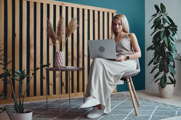 Young woman using laptop and holding online conference, remote work at home