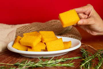 Portion of fried polenta . Polenta cubes.Typical Italian fried polenta. Fried corn sticks.