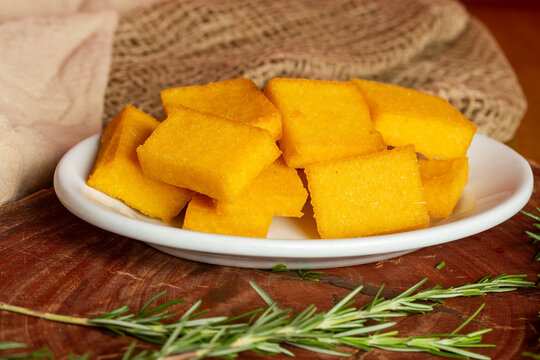 Portion of fried polenta . Polenta cubes.Typical Italian fried polenta. Fried corn sticks.