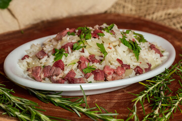 Arroz de Carreteiro - Typical food from southern Brazil, made with rice and dried meat  served on a white plate.