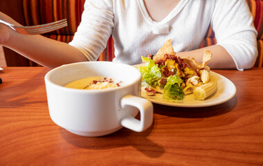 Woman Holding a fork eating healthy salad and soup