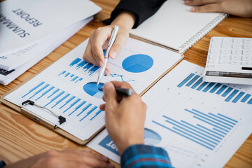 Business Asian people are meeting to analyze data figures to plan business strategy with financial paperwork. Business discussing, accounting bookkeeping concept