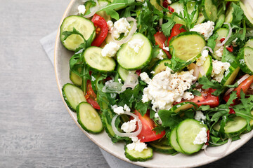 Plate of delicious cucumber salad on grey table, top view